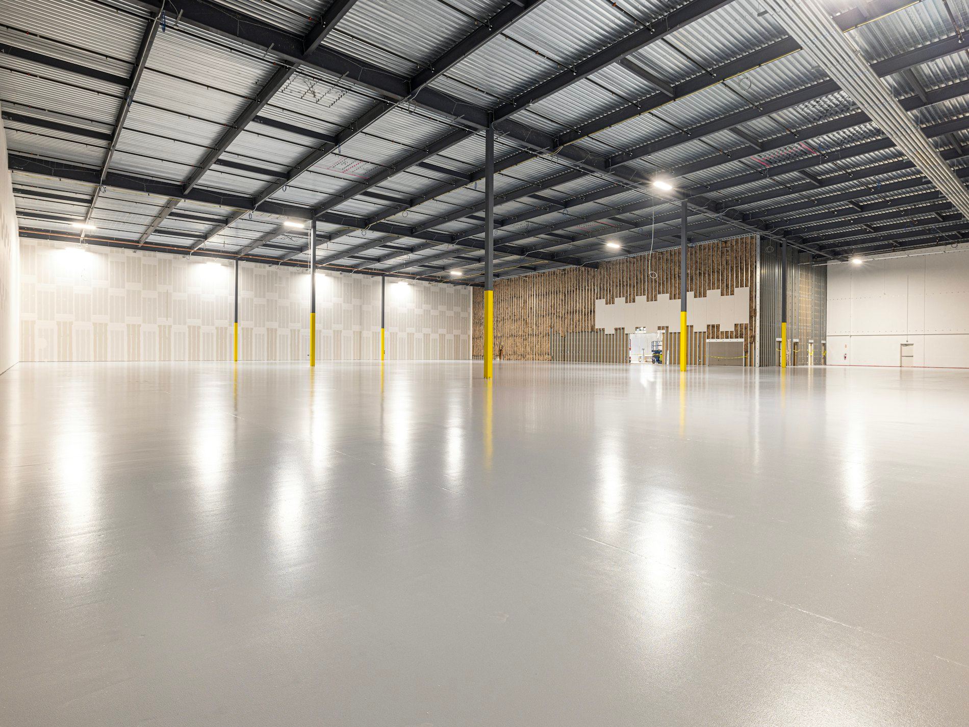 Empty industrial warehouse with a smooth polished concrete floor.